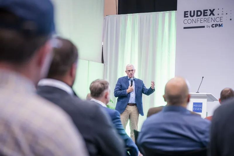 Referent spricht mit Mikrofon bei der EUDEX Conference des CPM Verlags vor Publikum in der Messe Essen