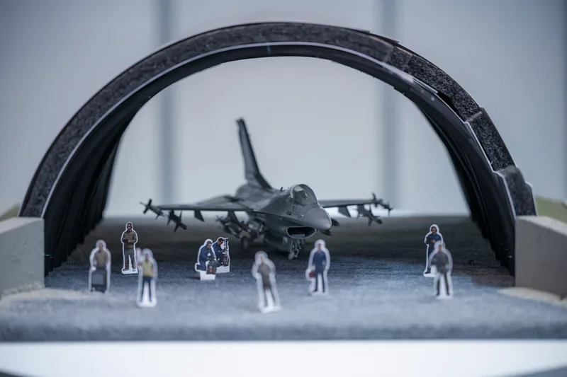 Modell einer F-16 Fighting Falcon in einer Flugzeugschutzhalle mit Figuren von Bodenpersonal als Diorama