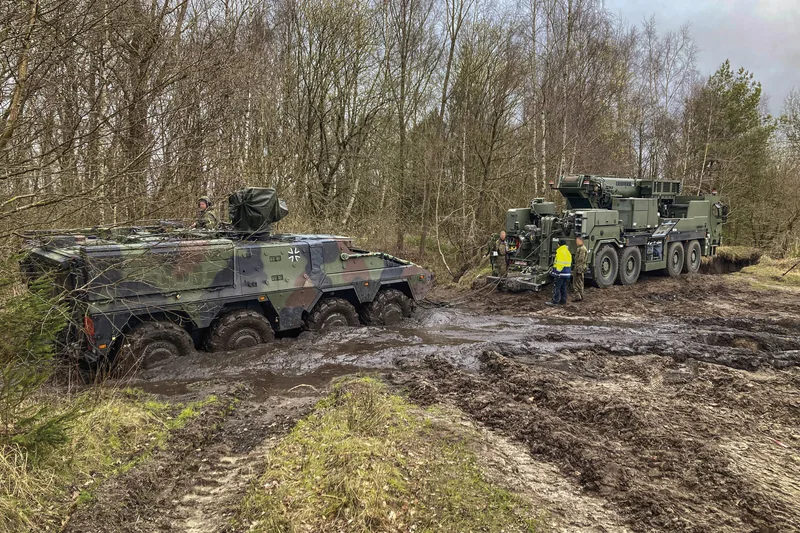Ein geschütztes Berge-Kranfahrzeug G-BKF von Liebherr birgt ein im Schlamm festgefahrenes GTK Boxer der Bundeswehr im Waldgelände