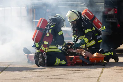 Einsatzkräfte helfen einem verletzten Betroffenen bei der Chemieunfallübung RedStorm Charlie in Hamburg.