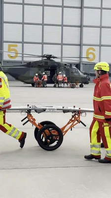 Video: Einsatzkräfte der DLRG und Soldaten der Bundeswehr trainieren an einem Transporthubschrauber vom Typ NH90 die medizinische Evakuierung und den Patiententransport mit Krankentragen auf einem Flugplatzgelände.