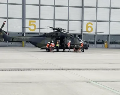 Video: Einsatzkräfte des Deutschen Roten Kreuzes und Sanitäter der Bundeswehr übernehmen an einem Transporthubschrauber des Typs NH90 auf einem Flugplatzvorfeld eine verletzte Person auf einer Trage.