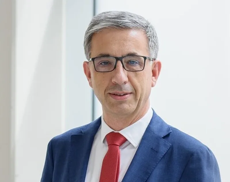 Prof. Wohlrab im blauen Sakko und roter Krawatte vor einer hellen Fensterfront