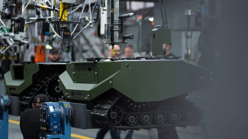 Techniker montieren unbemannte Kettenfahrzeuge von ARX Robotics in einer Produktionshalle von Deutz