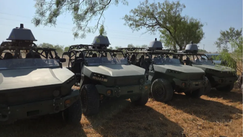 Vier GM Defense Infantry Squad Vehicles mit Überrollkäfigen und Dach-Sensoren für autonomes Fahren aufgereiht im Freigelände