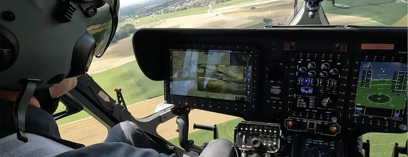 Blick aus der Cockpit-Perspektive eines Militärhubschraubers auf digitale Instrumente mit taktischer Lagekarte während des Fluges
