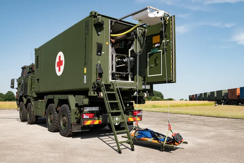 Geschützter Verwundetentransport-Container der Bundeswehr auf einem Militär-Lkw bei der Patientenaufnahme mittels Hebevorrichtung