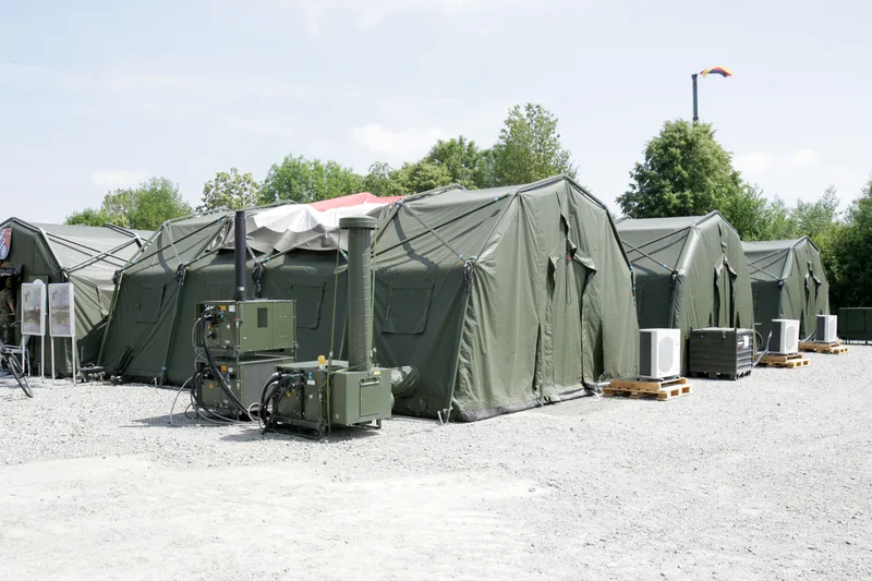 Aufbau eines mobilen Luftlanderettungszentrums der Bundeswehr mit Sanitätszelten, Feldklimageräten und Versorgungseinheiten auf einem Übungsgelände