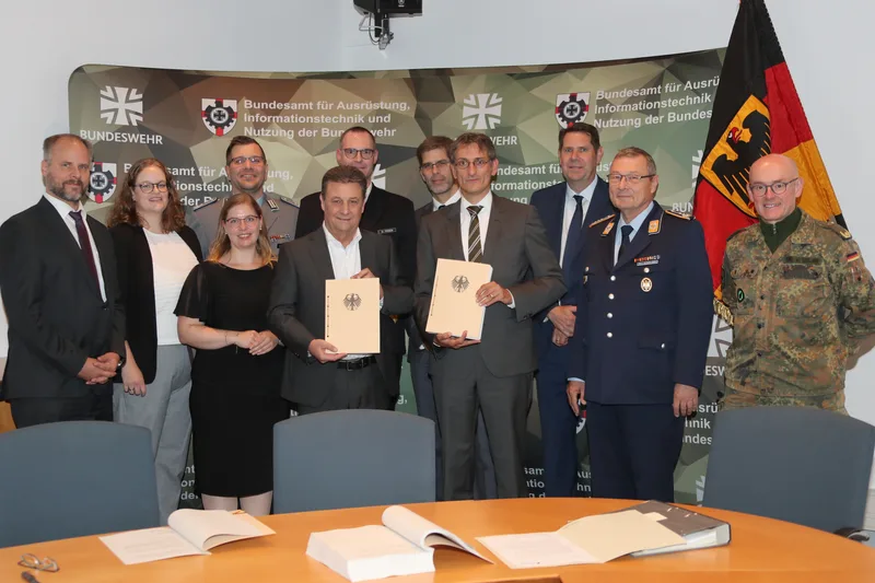 Vertreter des BAAINBw, der Bundeswehr und der Industrie präsentieren unterzeichnete Vertragsdokumente im BAAINBw