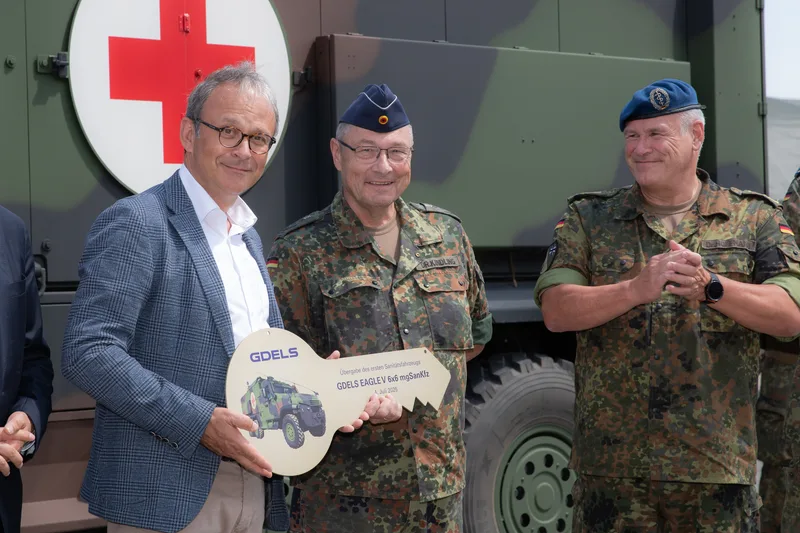 Vertreter von GDELS übergibt Angehörigen des Sanitätsdienstes der Bundeswehr einen symbolischen Schlüssel für ein Eagle V 6x6 Fahrzeug