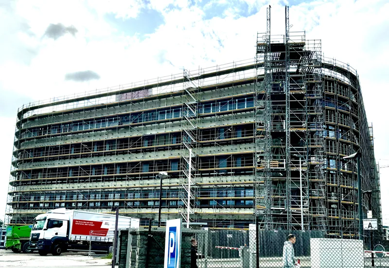 Eingerüstetes Multifunktionsgebäude auf einer Bundeswehr-Baustelle in Koblenz mit MAN-LKW und Sicherheitszaun