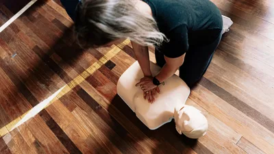 Woche der wiederbelebung: Laie führt während einer Erste-Hilfe-Ausbildung eine Herzdruckmassage an einem Reanimationstorso durch
