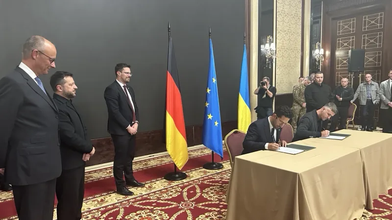 Wolodymyr Selenskyj und Friedrich Merz bei der Unterzeichnung einer Kooperationsvereinbarung von ARX Robotics in Kyjiw