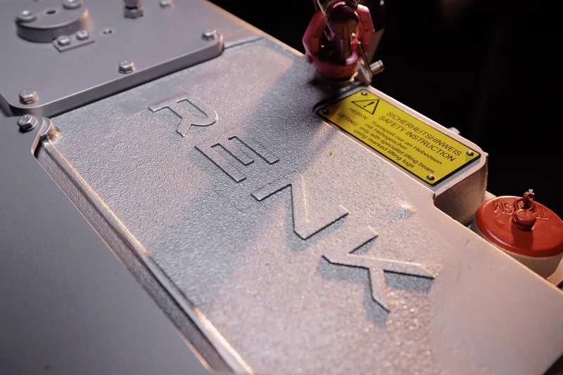 Getriebegehäuse von RENK mit erhabenem Firmenschriftzug, gelbem Sicherheitshinweis und einer Hebeöse auf der Metalloberfläche