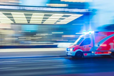 Malteser: Rettungswagen auf Mercedes-Benz Sprinter mit Blaulicht fährt am Bahnhof Potsdamer Platz in Berlin vorbei