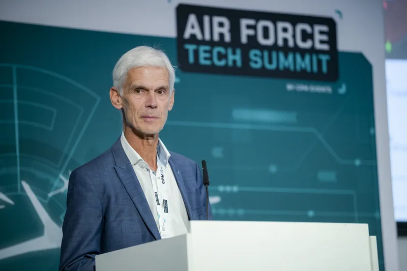 Referent am Rednerpult während der Fachkonferenz Air Force Tech Summit vor einer thematisch gestalteten Bühnenwand