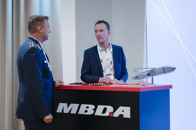 Luftwaffenoffizier im Gespräch mit einem MBDA-Vertreter am Messestand mit Modell eines unbemannten Flugkörpers beim Air Force Tech Summit