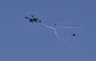 Abfang-Multikopter des Projekts FALKE schießt im Flug ein Fangnetz auf eine Zieldrohne zur Drohnenabwehr