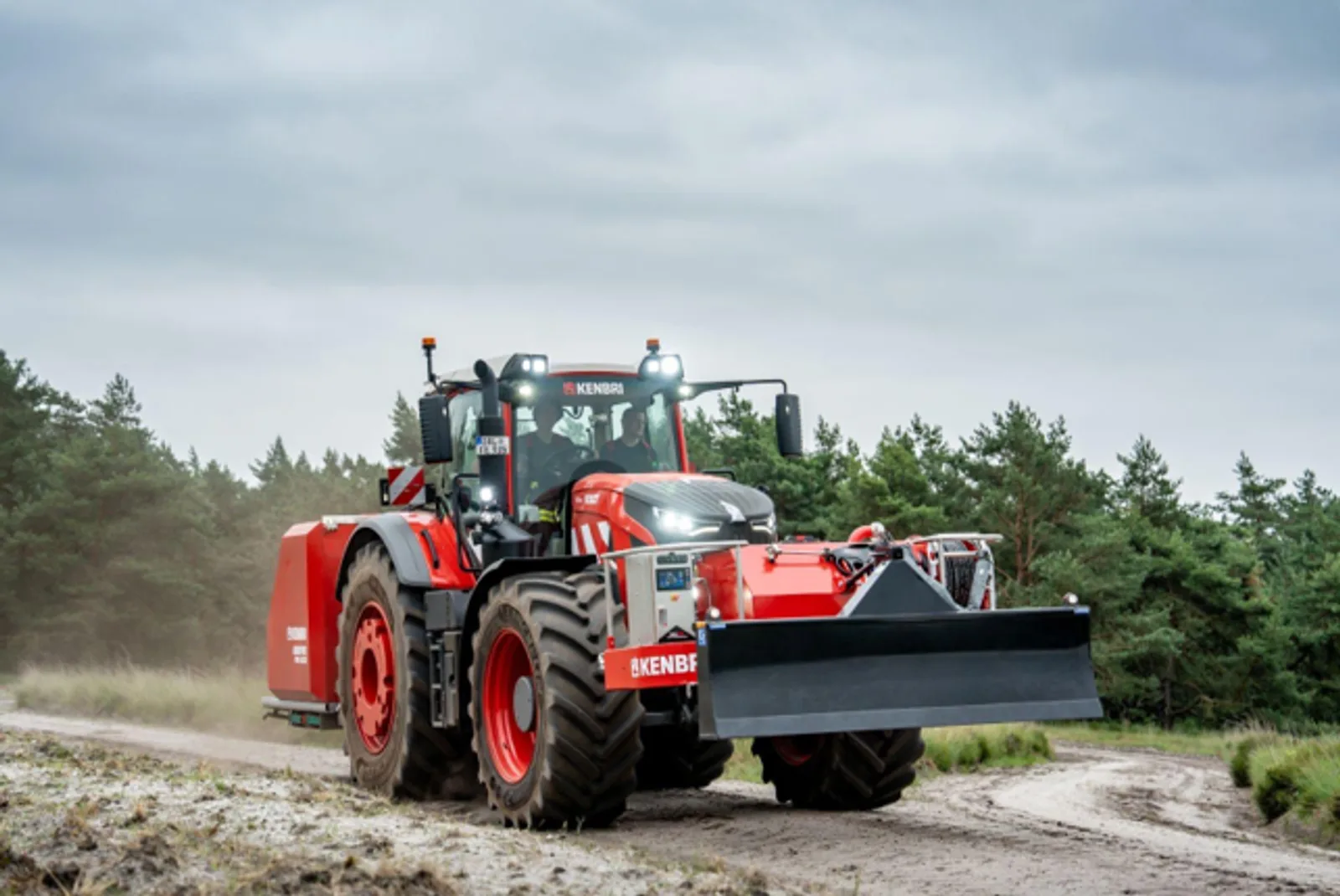 Kenbri-Großtraktor mit montiertem Räumschild fährt auf einem unbefestigten Waldweg zur Vegetationsbrandbekämpfung
