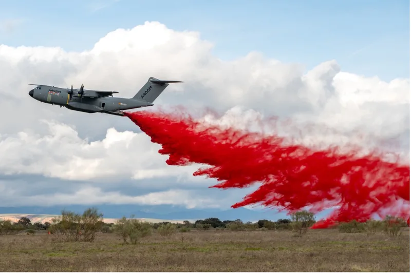 Airbus A400M der Luftwaffe im Tiefflug bei der Erprobung der luftgestützten Brandbekämpfung mit roter Löschflüssigkeit