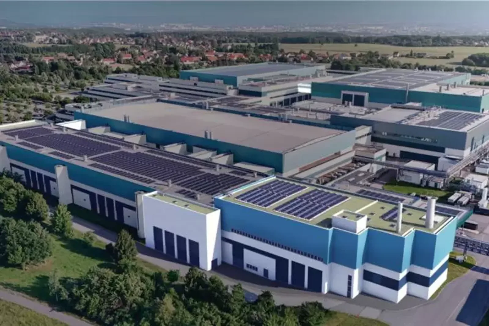 GlobalFoundries: Luftaufnahme eines Industriekomplexes mit großflächigen Photovoltaikanlagen auf den Flachdächern der Fabrikhallen