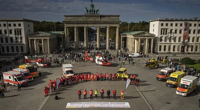 Notfallreform: Einsatzkräfte mit Rettungswagen und DRF- sowie ADAC-Notarzthubschraubern bei einer Demonstration vor dem Brandenburger Tor in Berlin