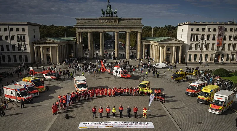 Notfallreform: Einsatzkräfte mit Rettungswagen und DRF- sowie ADAC-Notarzthubschraubern bei einer Demonstration vor dem Brandenburger Tor in Berlin