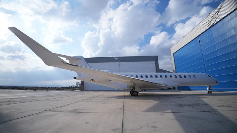 Weißes Geschäftsreiseflugzeug vom Typ Bombardier Global auf dem Vorfeld vor den Hangars von Bird Aviation