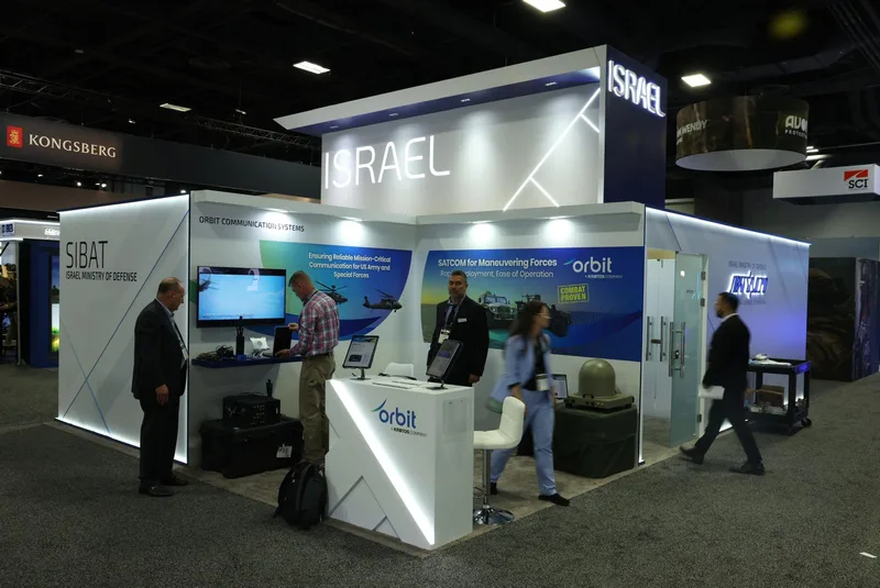 Messestand von Orbit Communication Systems im israelischen SIBAT-Pavillon auf einer Rüstungsmesse mit Fachbesuchern und Exponaten