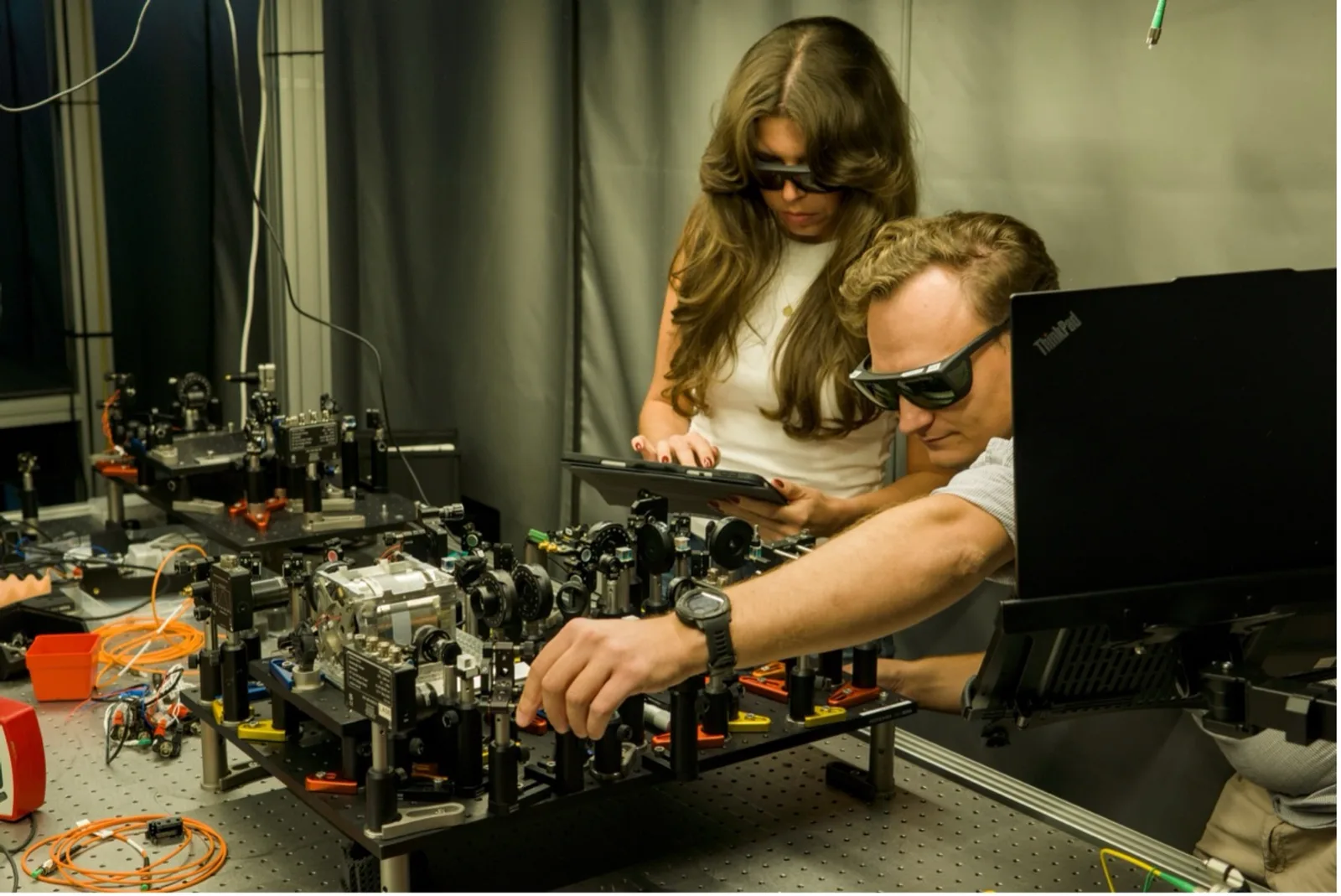 Zwei Forschende von Arda Atomics mit Laserschutzbrillen justieren einen optischen Versuchsaufbau an einem Labortisch bei Arda Atomics