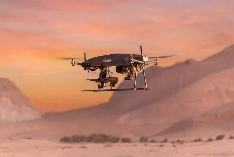 Bewaffnete Drohne von Israel Aerospace Industries (IAI) mit Waffenstation und Sensorik im Flug über einer Wüstenlandschaft