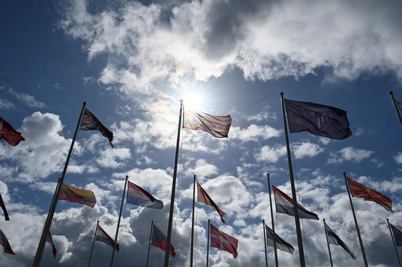 Nationalflaggen von NATO-Mitgliedsstaaten und die Flagge des Joint Warfare Centre wehen vor blauem Himmel in Norwegen