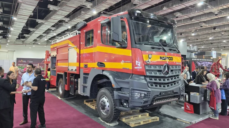 NAFFCO-Feuerwehrfahrzeug auf Mercedes-Benz-Fahrgestell mit Standpersonal und Besuchern auf einer Fachmesse in einer Messehalle