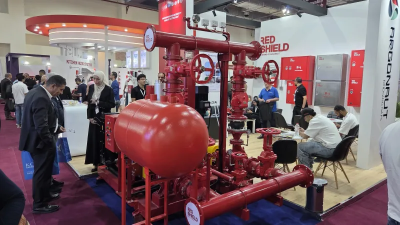 Argonaut Messestand der Marke Red Shield mit Brandschutzpumpenanlage, Druckbehälter und Besuchern auf einer Fachmesse