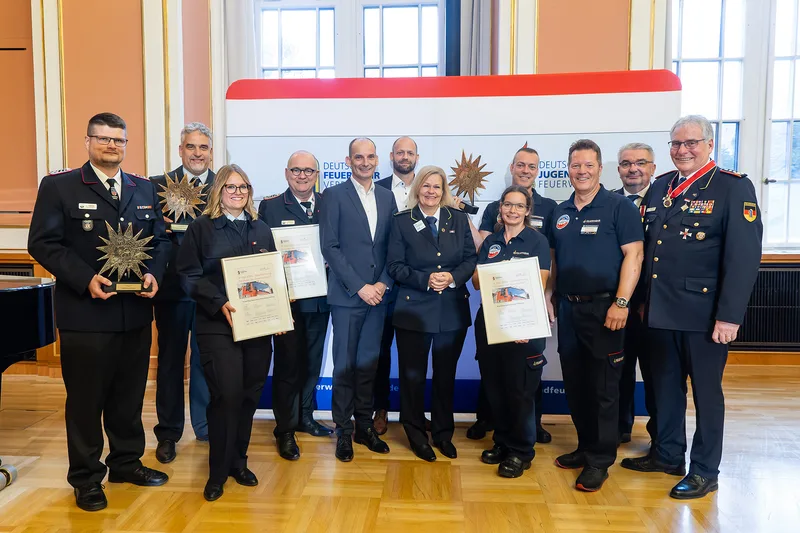 Preisträger und Vertreter des Deutschen Feuerwehrverbandes sowie der Deutschen Jugendfeuerwehr präsentieren IF Star-Trophäen