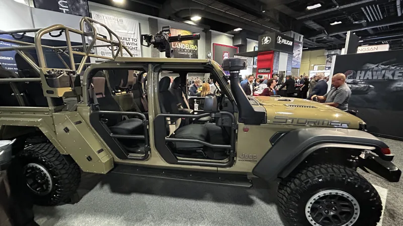 Militärisches Einsatzfahrzeug Stormer auf Basis eines Jeep Gladiator mit Dachbewaffnung auf einer Rüstungsmesse mit Fachbesuchern