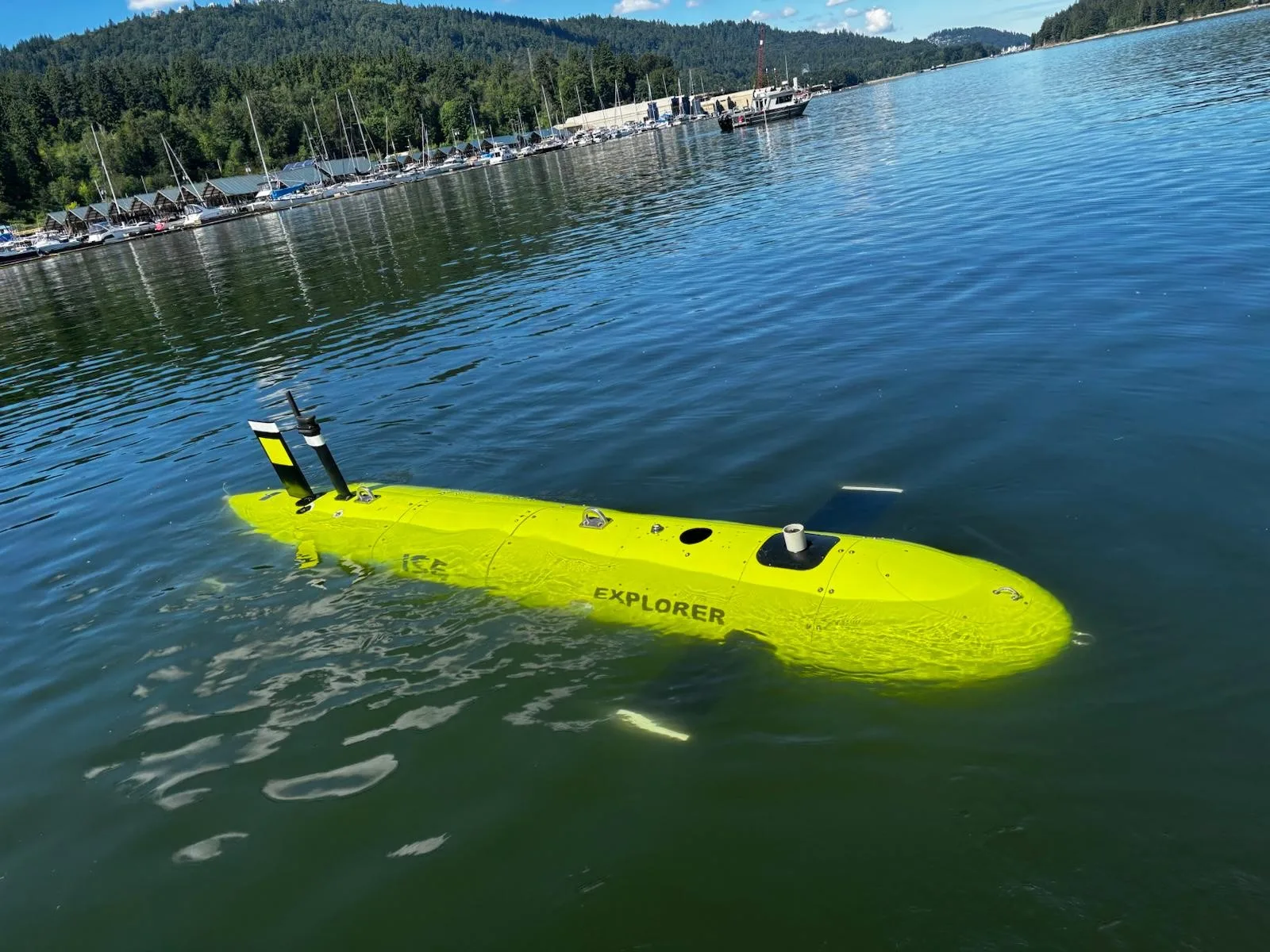 Elbit Systems Autonomes Unterwasserfahrzeug Explorer von International Submarine Engineering an der Wasseroberfläche vor einem Küstenabschnitt
