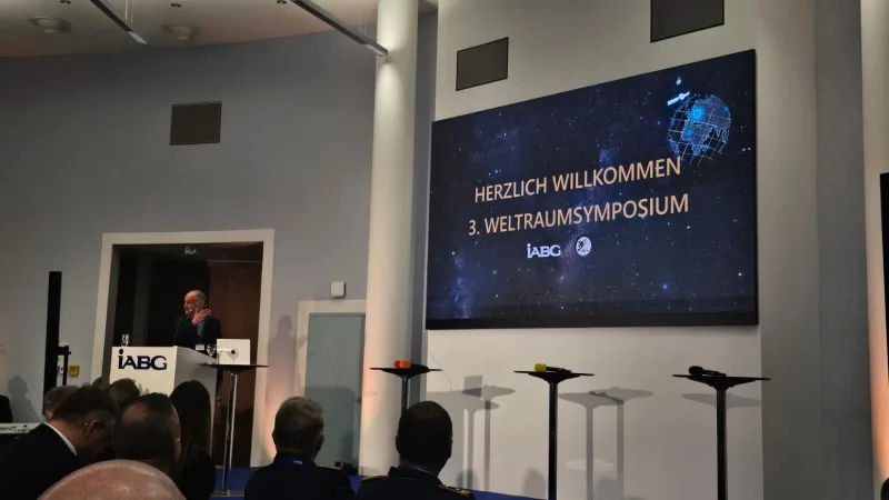 Referent am IABG-Rednerpult vor Auditorium mit Bundeswehrangehörigen und Branchenvertretern beim 3. Weltraumsymposium der IABG