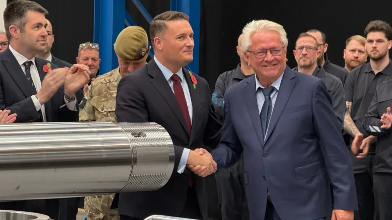 Rheinmetall-Vorstandsvorsitzender Armin Papperger (rechts) besiegelt im Beisein von Gästen aus Politik und britischen Streitkräften die Einweihung der UK Gun Hall.