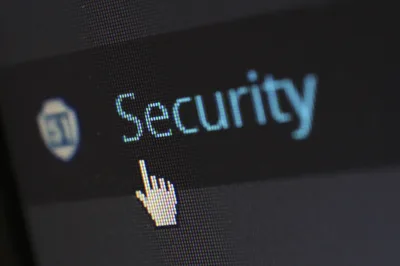 Cybersecurity: Nahaufnahme eines Bildschirms mit dem Schriftzug “Security”, einem Schildsymbol und einem Hand-Cursor
