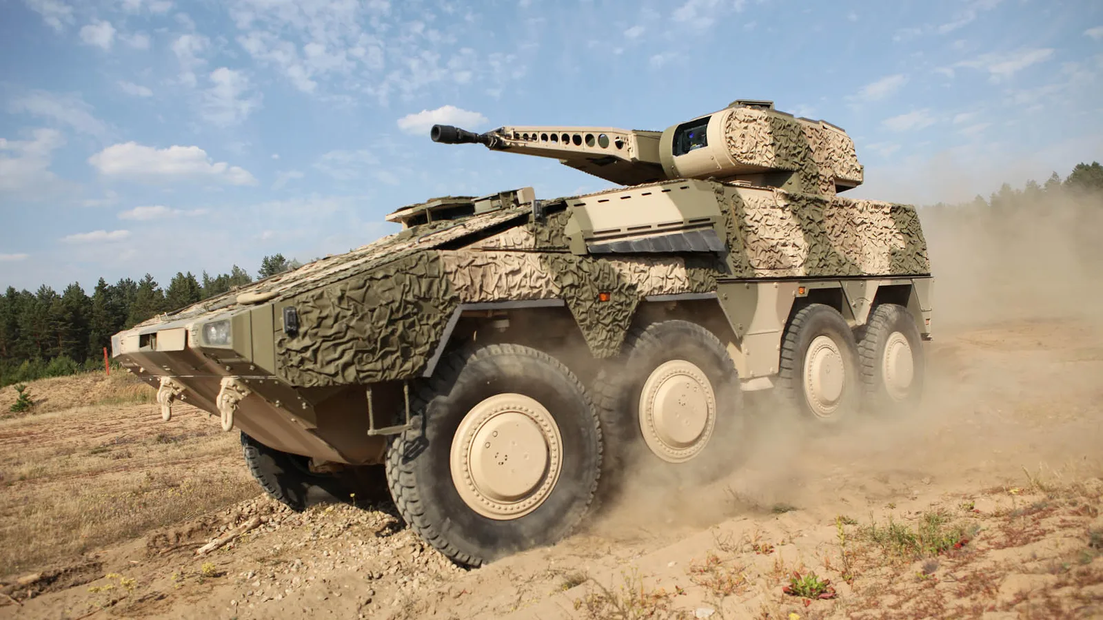 Schakal: Radpanzer Boxer mit RCT30-Turm und Tarnausstattung bei einer Geländefahrt auf sandigem Untergrund mit Staubentwicklung