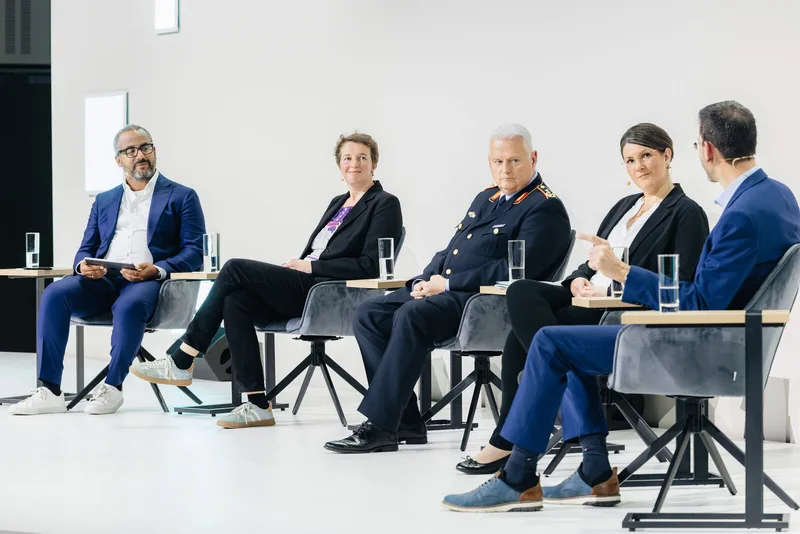 General der Luftwaffe der Bundeswehr und Experten aus Wirtschaft und Zivilgesellschaft bei einer Podiumsdiskussion auf einer Bühne