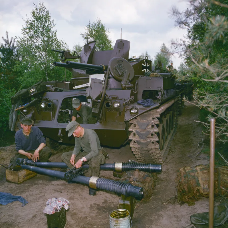 Zwei Bundeswehrsoldaten reinigen im Wald die demontierten Rohre der 40-mm-Zwillingsflak eines Flugabwehrpanzers M42 Duster