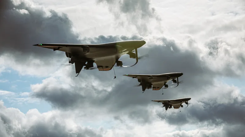 Drei unbemannte VTOL-Nurflügler fliegen in Formation vor bewölktem Himmel