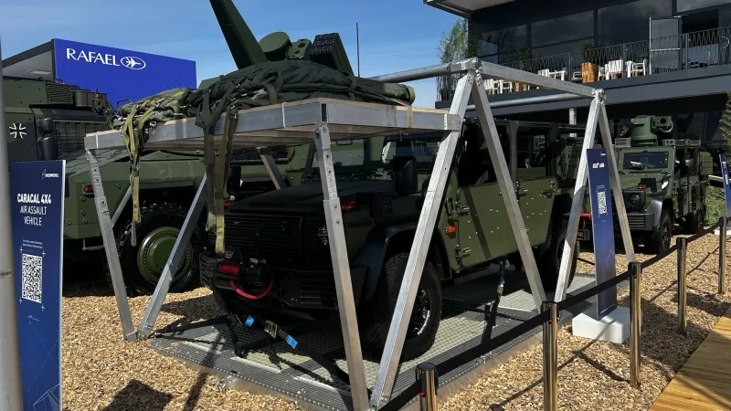 Luftlandefahrzeug Caracal von Rheinmetall auf einer Transportplattform vor weiteren Militärfahrzeugen und Messeständen