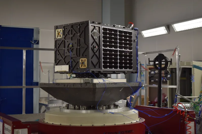 Kleinsatellit mit Solarzellen auf einem Vibrationsprüfstand von Actidyn Systèmes während eines mechanischen Belastungstests